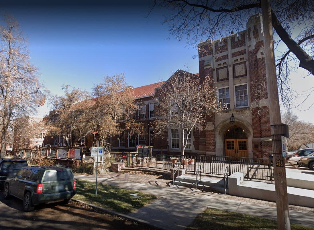 Historic brick institutional building on a tree-lined city street