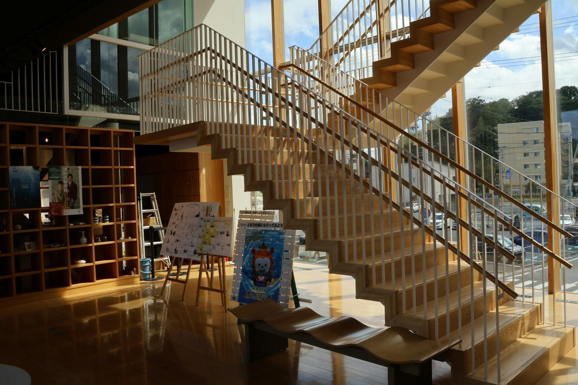 Bright community learning space with an open staircase and bookshelves